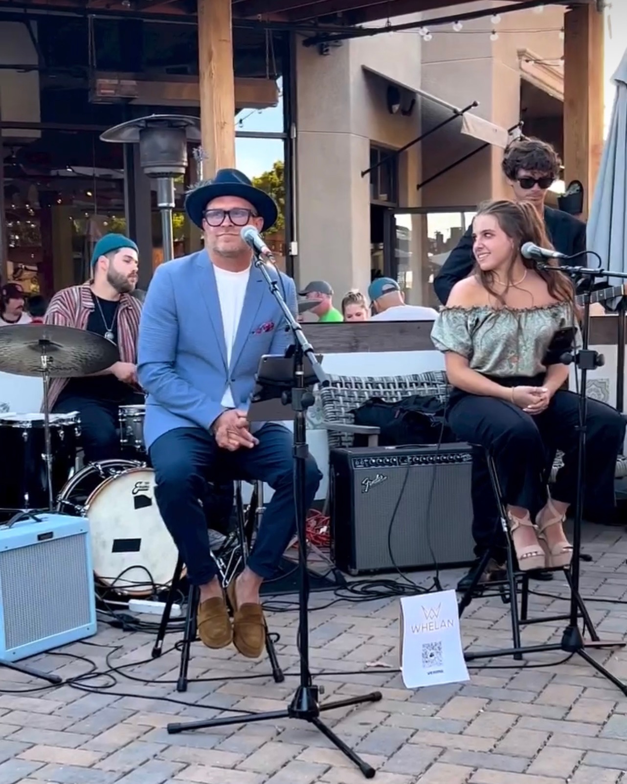 Rowdy Band musicians performing a seated set on a restaurant patio