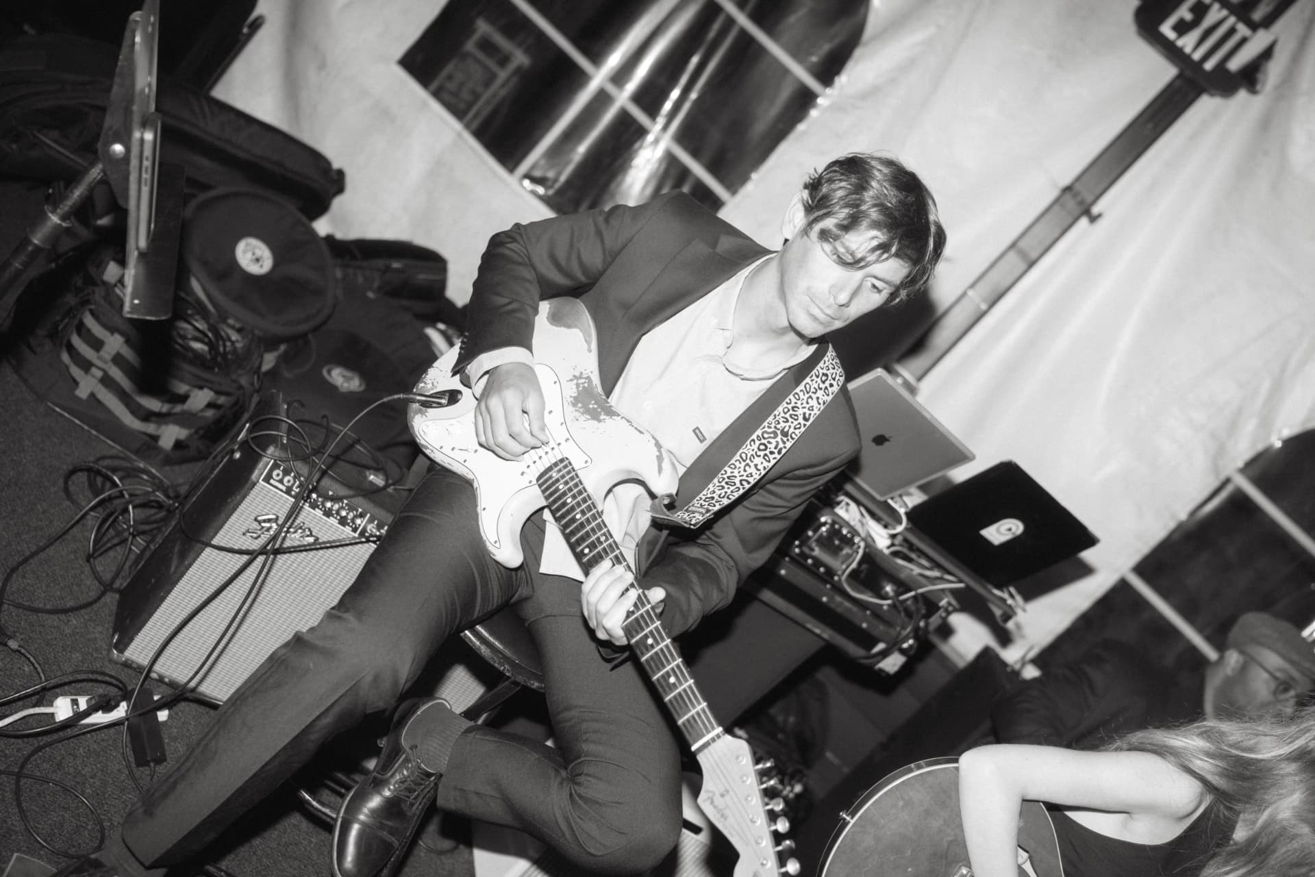 Albert playing a white electric guitar during a live performance