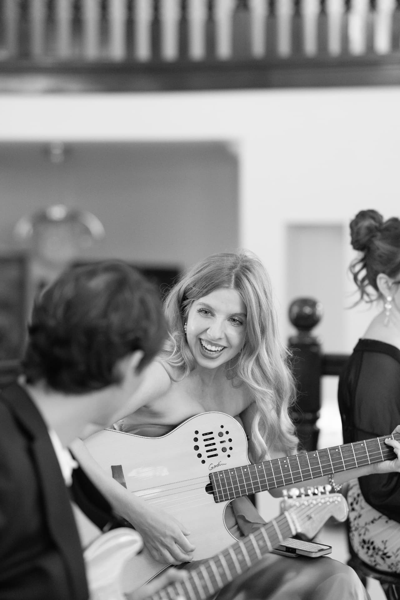 Kateland Raftery smiling while playing guitar during a live performance
