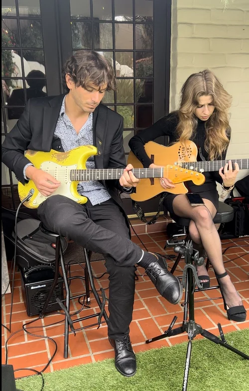 Albert playing electric guitar alongside Kateland at an intimate performance