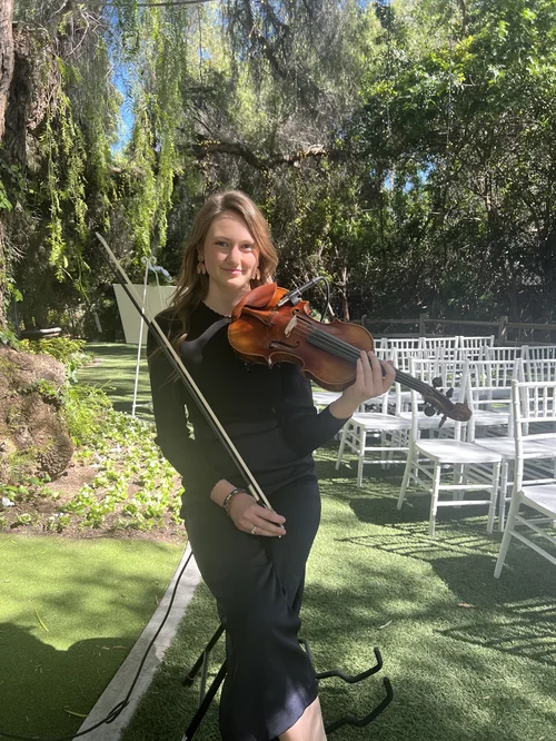 Violinist ready to perform at an outdoor wedding ceremony