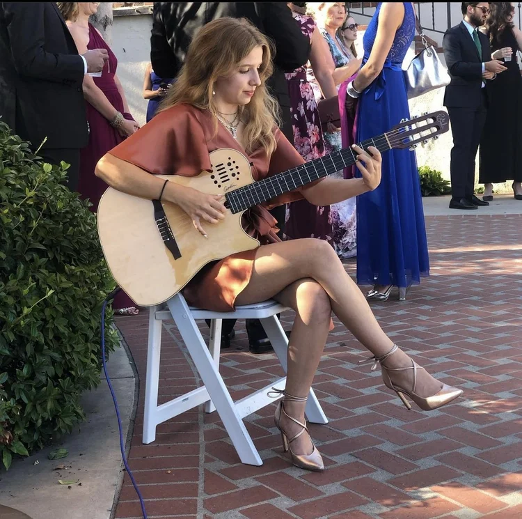 Kateland Raftery playing guitar for guests at a wedding